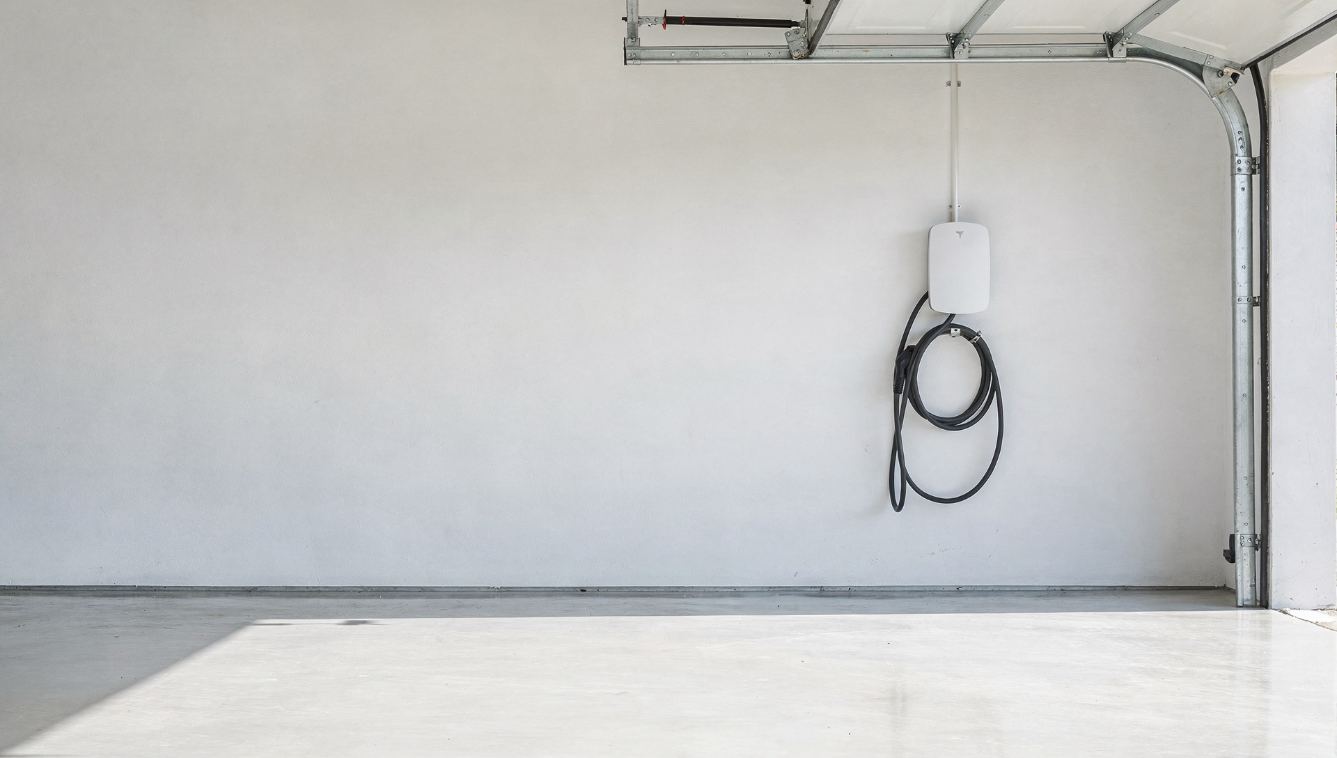 A clean white EV wall charger neatly installed in a bright residential garage